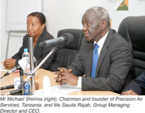 "Leadership Discussion at Precision Air Services Conference" "Mr. Michael Simba and Ms. Sadiki during a business discussion."