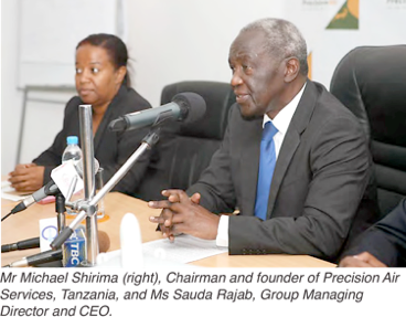 "Leadership Discussion at Precision Air Services Conference" "Mr. Michael Simba and Ms. Sadiki during a business discussion."