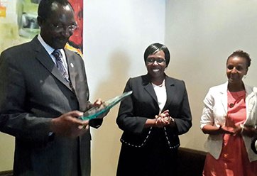 "Honouring Achievements: Award Ceremony Highlights" "A dignitary receives an award, accompanied by two clapping attendees."